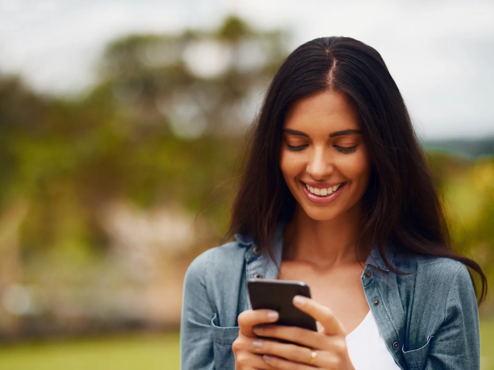 Woman smiling at her phone while shopping